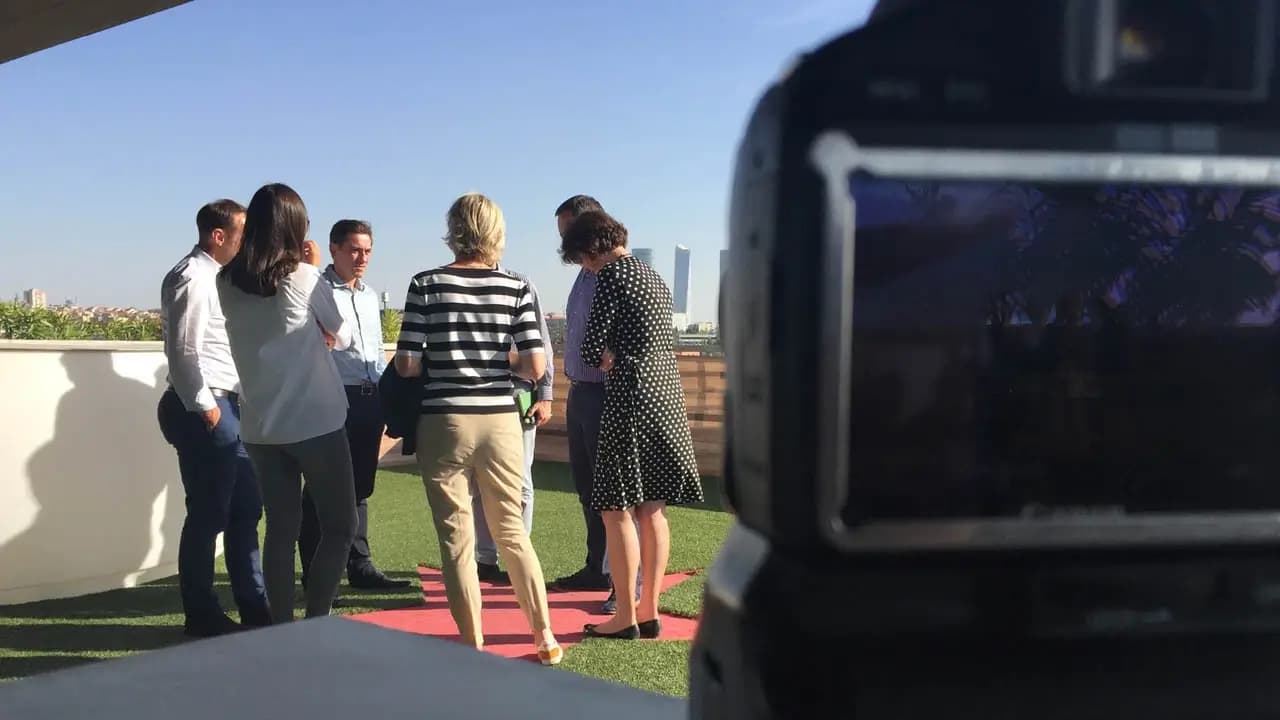 Group of professionals congregating on balcony above Madrid