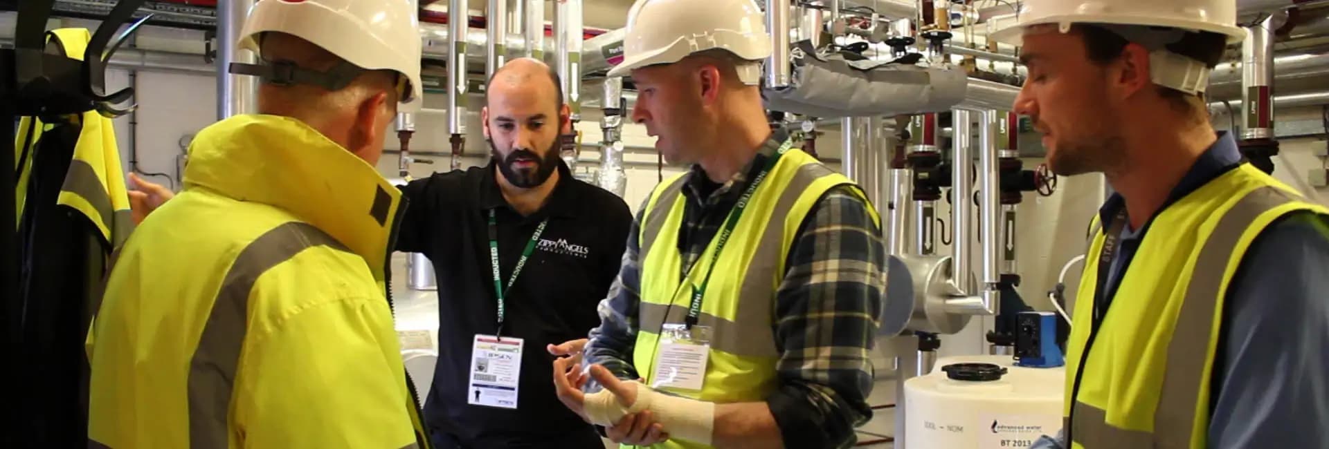 Director informing actors dressed in high-viz clothing on shoot of corporate training film