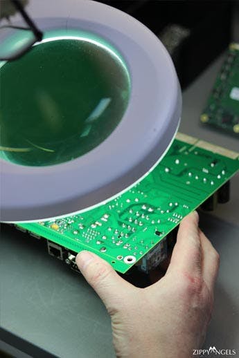 Close up of circuit board being looked at through magnifying lens